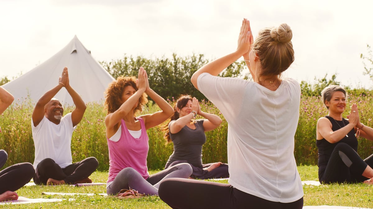 Grupo de personas meditando al aire libre en la naturaleza